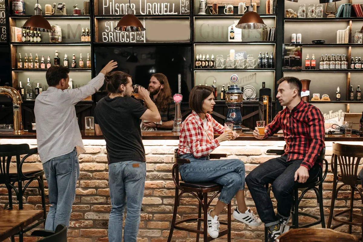 A group of friends socializing and enjoying drinks at a lively bar.