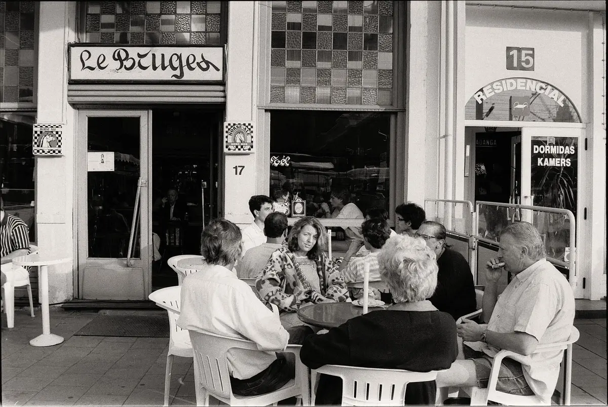Group of people enjoying a conversation at an outdoor cafe.